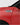 Close-up of a sleek red car showing a stylish chrome side vent design